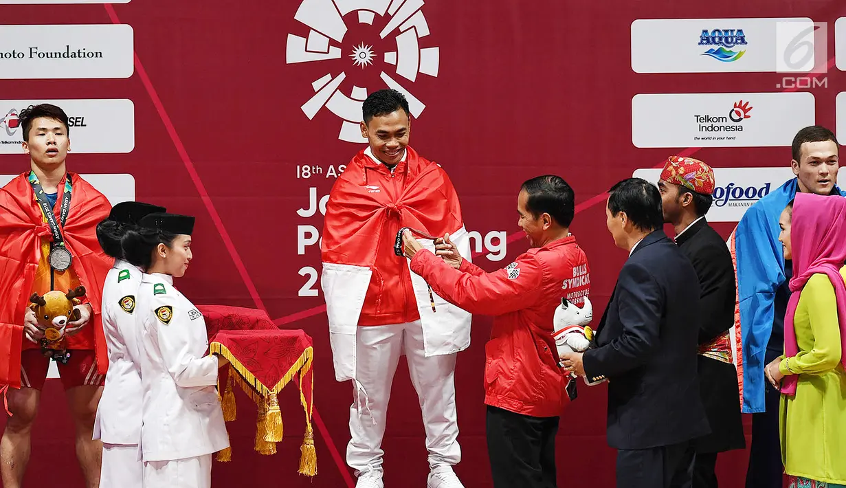 Presiden Joko Widodo memberikan mendali emas kepada atlet angkat besi Indonesia Eko Yuli Irawan setelah berhasil memenangkan pertandingan Angkat Besi pada  Asian Games 2018 di JIexpo, Kemayoran,Jakarta, Selasa (21/8). (merdeka.com/Imam Buhori)