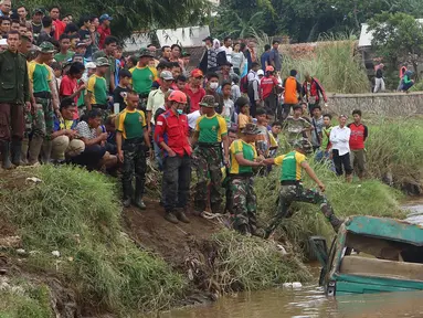 Prajurit Kostrad TNI AD bersama sukarelawan menyisir bangkai mobil yang diduga terdapat jenazah korban musibah banjir bandang di Cimacan, Garut (23/9). Data terakhir, tercatat sementara korban jiwa mencapai 26 orang. (Liputan6.com/Johan Tallo)
