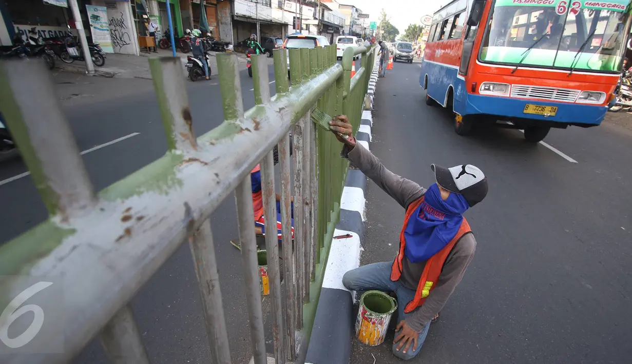 Pekerja mengecat pagar pembatas jalan di kawasan Pasar Minggu, Jakarta Selatan, Rabu (26/10). Pengecatan dilakukan sebagai bentuk perawatan agar pagar pembatas tetap rapi dan tidak tampak kusam. (Liputan6.com/Immanuel Antonius)