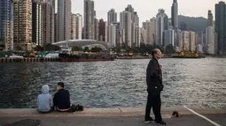 Orang-orang bersantai di dermaga umum di sebelah Pelabuhan Victoria di Hong Kong (3/3). Pemandangan yang spektakuler membuat pelabuhan ini menjadi daya tarik wisata utama Hong Kong. (AFP Photo/Dale De La Rey)