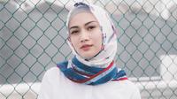 Memakai hijab berwarna putih dengan corak biru dan merah, membuat penampilan Melody terkesan santai dan elegan. (Liputan6.com/IG/@melodylaksani92)