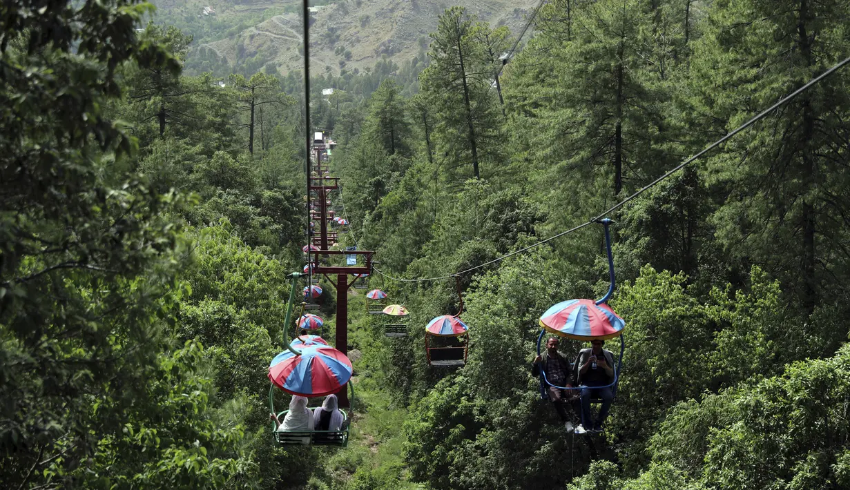 <p>Wisatawan menikmati naik kursi gantung di kota resor bukit Murree, selama hari pertama Idul Fitri di dekat Islamabad, Pakistan, Selasa, 3 Mei 2022. (AP Photo/Rahmat Gul)</p>