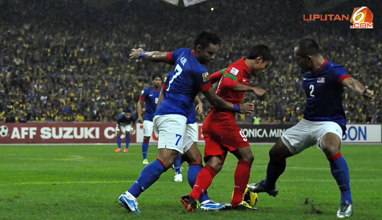 Pemain Indonesia, Samsul Arif (tengah) berusaha keluar dari hadangan pemain Malaysia dalam Laga Piala AFF Suzuki 2012 antara Malaysia vs Indonesia di Stadion Bukit Jalil, Kuala Lumpur, Malaysia. pertandingan berakhir dengan skor 2-0 untuk Malaysia.
