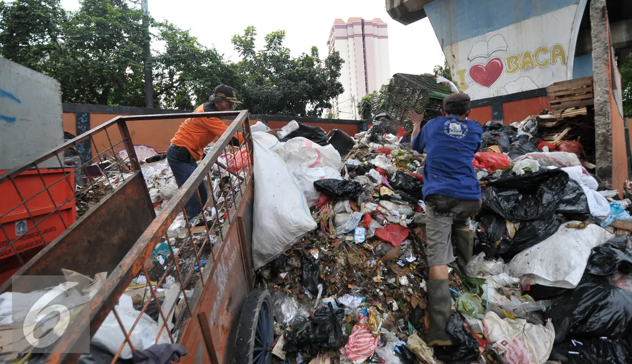Petugas kebersihan mengumpulkan sampah di lokasi tempat pembuangan sampah sementara (TPSS), Pasar Baru, Jakarta, Jumat (25/11). Para cagub juga harus memiliki program untuk mengatasi permasalahan lingkungan di Jakarta. (Liputan6.com/Yoppy Renato)