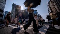Gelombang panas semakin intens dan sering terjadi di seluruh dunia akibat perubahan iklim. Tampak dalam foto, Orang-orang menyeberang jalan di Tokyo pada 4 Agustus 2025. (Kazuhiro NOGI/AFP)
