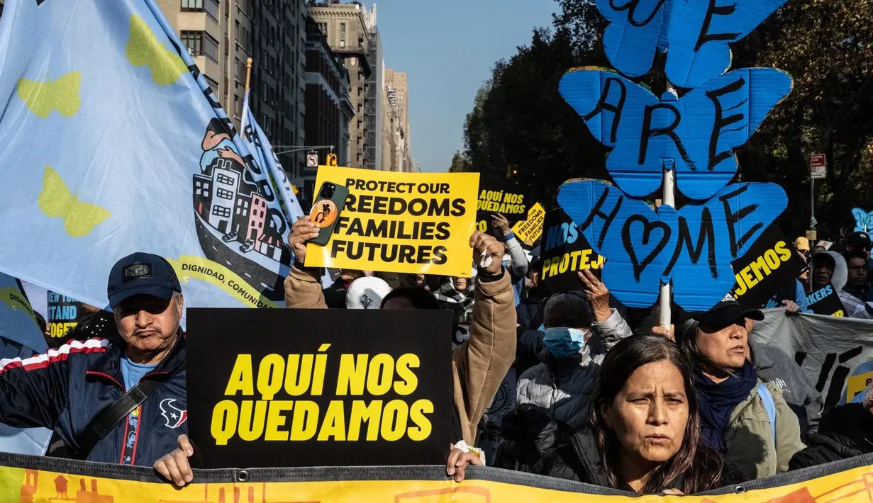 Salah satu pengunjuk rasa memegang papan bertuliskan dalam bahasa Spanyol “Kami akan tetap di sini”, saat para imigran dan aktivis berpartisipasi dalam aksi unjuk rasa pada 9 November 2024 di New York City, Amerika Serikat. (Stephanie Keith/Getty Images North America/Getty Images via AFP)