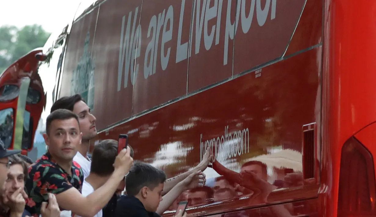Penggemar Liverpool menyambut bus tim saat tim tiba di hotel di Kiev, Ukraina, (24/5). Liverpool akan bertanding melawan Real Madrid di Final Liga Champions pada 26 Mei di stadion Olympiyski di Kiev. (AP Photo/Sergei Grits)