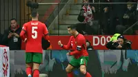 Penyerang Timnas Portugal, Cristiano Ronaldo, mencetak gol ke gawang Polandia dalam laga UEFA Nations League, Minggu (13/10/2024) dini hari WIB. (Sergei GAPON / AFP)