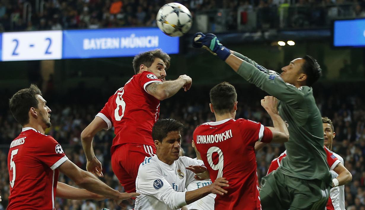 Kiper Real Madrid, Keylor Navas (kanan) menghalau bola dari kejaran para pemain Bayern Munchen pada leg kedua semifinal Liga Champions di Santiago Bernabeu stadium, Madrid, (1/5/2018). Madrid bermain imbang 2-2. (AP/Paul White)