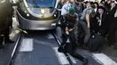 Pasukan keamanan Israel saling tarik-menarik dengan demonstran Yahudi Ultra-Ortodoks yang memblokir jalan utama saat melakukan aksi menentang wajib militer Israel di Yerusalem (17/10). (AFP Photo/Menahem Kahana)