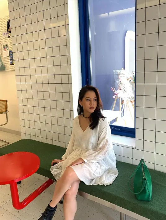 Lihat lagi gaya feminin Zara dibalut dress putih yang sederhana. Midi dress yang dikenakannya memiliki detail lengan balon berkerut yang manis. [Foto: Instagram/zaraadhsty]