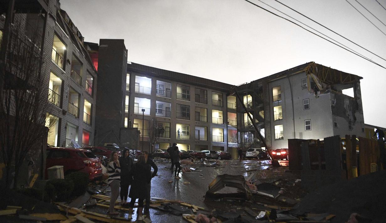 Puing-puing tersebar di tempat parkir gedung apartemen yang rusak setelah tornado menghantam Nashville, Selasa, (3/3/2020). Pihak berwenang meminta kepada warga untuk tetap tinggal di dalam rumah. (Courtney Pedroza / The Tennessean via AP)