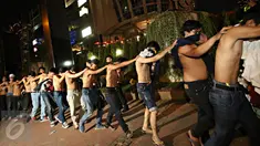 Puluhan remaja yang diduga sebagai The Jak Mania diamankan petugas di Jalan Sudirman, Jakarta, Minggu (18/10).  Mereka disuruh telanjang dada dan kemudian diangkut ke Polda Metro Jaya usai terlibat bentrokan dengan polisi. (Liputan6.com/Immanuel Antonius)