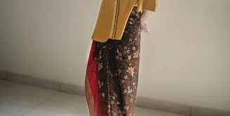 Untuk outfit kondangan sederhana, Binhpuse memadukan Tumeric Gold Blouse dengan kain batik. Menampilkan siluet yang elegan dan kecantikan yang eksotis dalam satu tampilan. (instagram/binhouse_official)