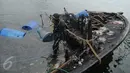 Petugas Basarnas dan Pol air menggunakan drum untuk mengangkat bangkai kapal Zahro Express di Pelabuhan Muara Angke, Jakarta, Rabu (4/1). Puluhan drum kosong dipasang di sekeliling kapal untuk mengangkat kapal perlahan-lahan. (Liputan6.com/Gempur M Surya)