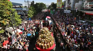 Ribuan warga berkumpul saat kendaraan hias yang ditumpangi Presiden Joko Widodo (Jokowi) dan Ibu Negara, Iriana Joko Widodo selama Karnaval Kemerdekaan Pesona Parahyangan 2017 melintas di pusat Kota Bandung, Sabtu (26/8). (Liputan6.com/Johan Tallo)