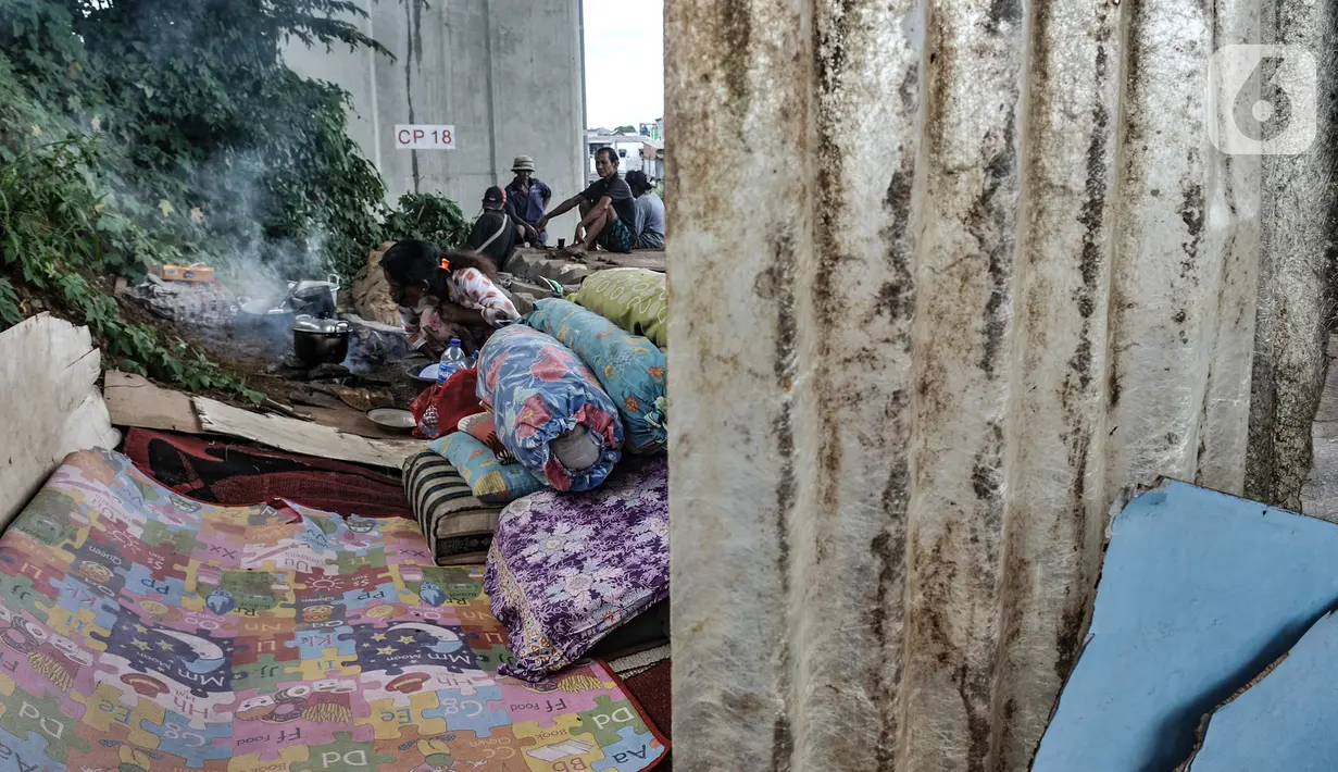 Seorang tunawisma memasak di dekat tempat tidurnya di kolong rel dwi ganda di kawasan Manggarai, Jakarta, Kamis (7/1/2021). Mereka yang terpaksa berprofesi sebagai pemulung memilih tinggal di kolong rel akibat ketimpangan sosial yang semakin tinggi di Ibu Kota. (merdeka.com/Iqbal S. Nugroho)