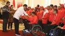 Presiden Joko Widodo memberi bonus kepada atlet Para Powoerlifting, Rayahu sebesar Rp 20 juta sebagai perwakilan dari atlet tidak mendapatkan medali pada Asian Para Games 2018 di Istana Bogor, Jakarta, Sabtu (13/10). (Liputan6.com/HO/Randy)