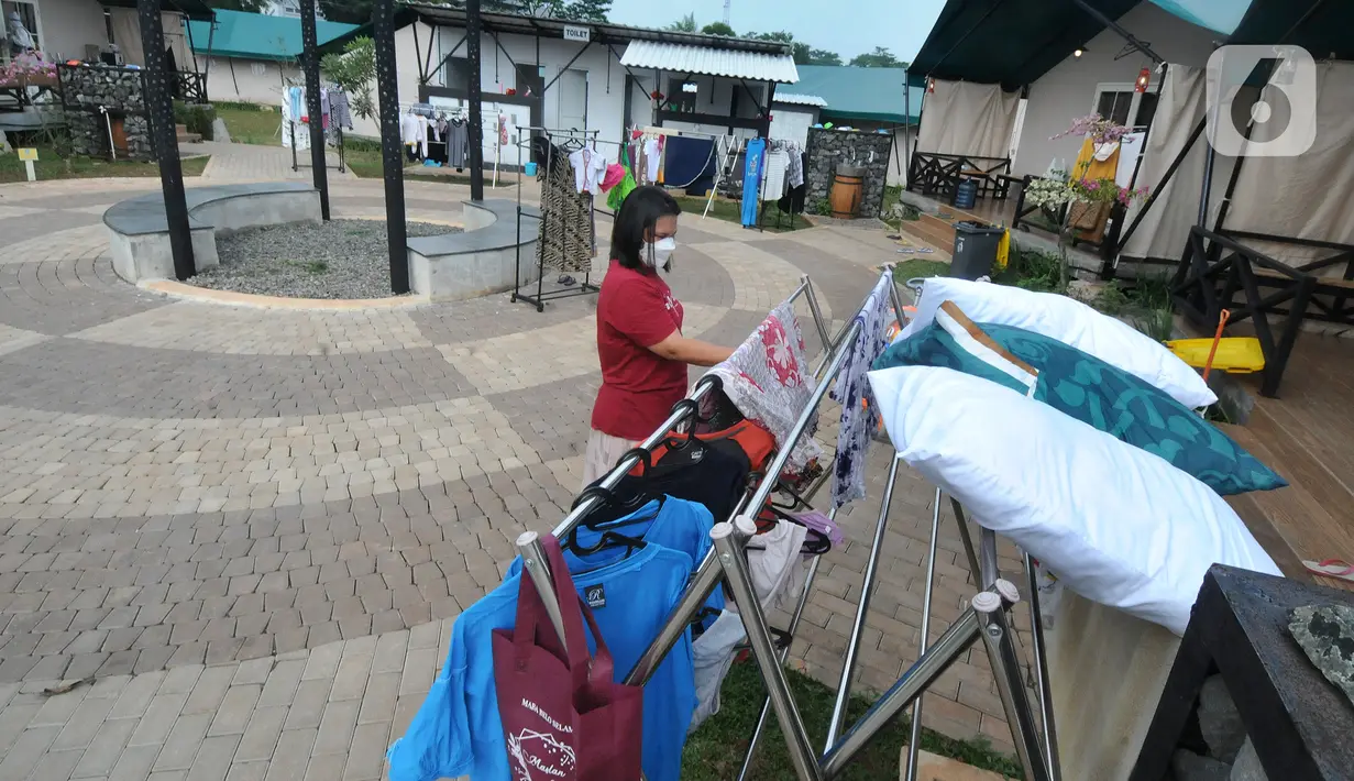 Seorang perempuan menjemur pakaian di luar Rumah Lawan COVID-19 (RLC) Serpong, Tangerang Selatan, Banten, Rabu (2/6/2021). RLC merawat lebih dari 60 pasien positif covid-19 yang melonjak drastis lebih dari 50 persen pasca lebaran. (merdeka.com/Arie Basuki)