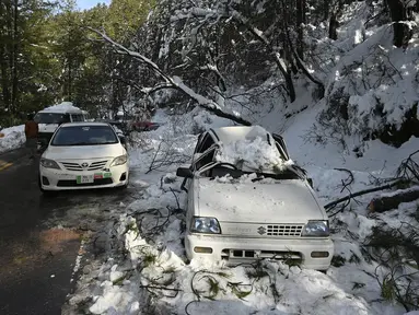 Seorang tentara berdiri dekat mobil saat operasi penyelamatan wisatawan yang terjebak salju tebal di sepanjang jalan Bukit Murree, Pakistan, 9 Januari 2022. Sebanyak 22 wisatawan tewas saat sekitar 1.000 kendaraan terjebak salju tebal di Bukit Murree. (Aamir QURESHI/AFP)