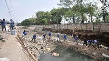 Pekerja Dinas Sumber Daya Air Jaktim menyelesaikan perbaikan turap di daerah aliran Kali Sunter, Jakarta, Rabu (31/10). Perbaikan ini merupakan bagian proyek normalisasi kali guna antisipasi banjir di kala musim penghujan. (Merdeka.com/Iqbal S. Nugroho)