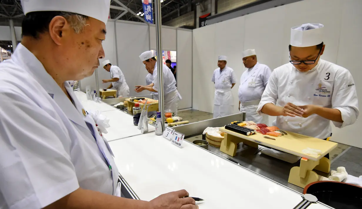 Seorang juri (kiri) memeriksa sushi buatan para peserta pada World Sushi Cup Japan 2016 di Tokyo, Kamis (18/8). 27 koki dari 14 negara mengikuti kompetisi membuat sushi ini. (Toru Yamanaka / AFP)