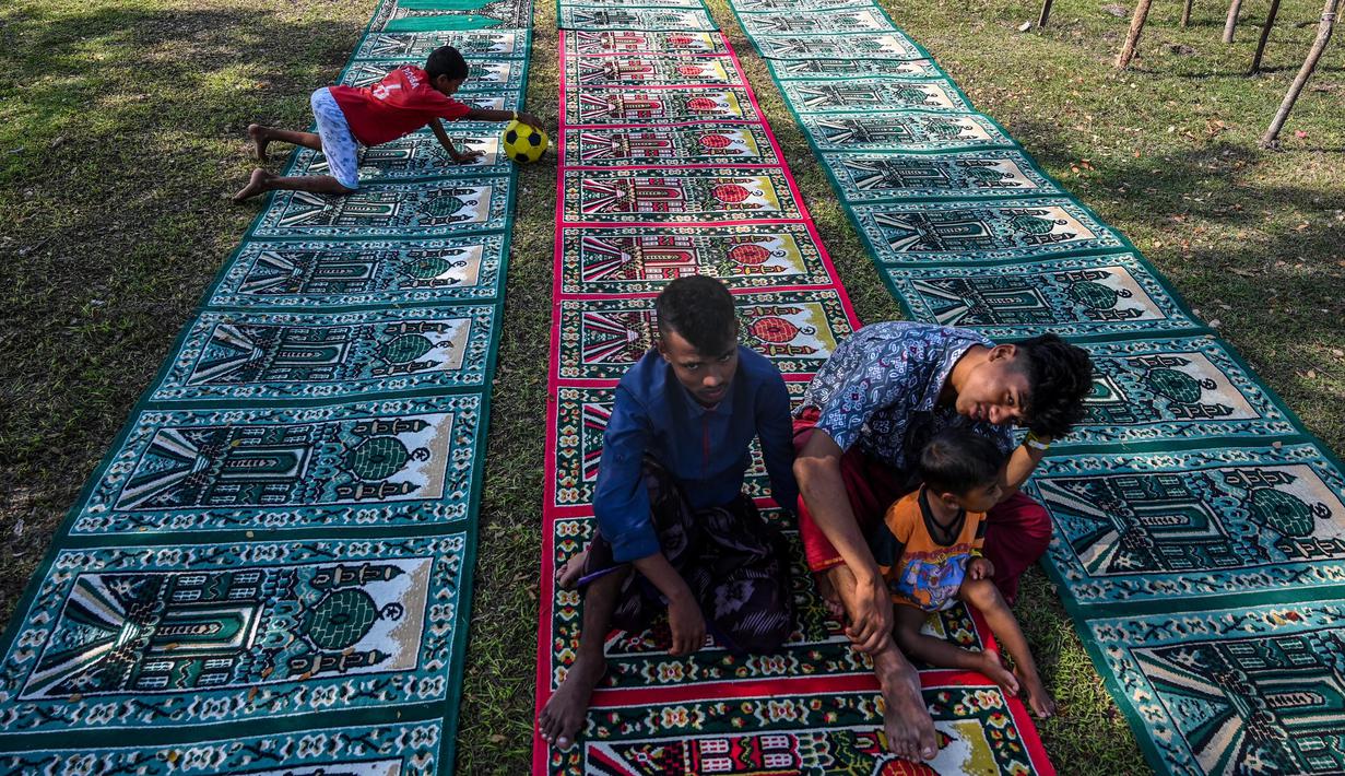 Pengungsi Rohingya mandi di tempat penampungan sementara di Ladong, provinsi Aceh, Jumat 24 Februari 2023. Sedikitnya 69 pengungsi Rohingya mendarat di pantai barat Indonesia pada 16 Februari lalu dengan sebuah perahu kayu, kata seorang pejabat badan pengungsi PBB. (CHAIDEER MAHYUDDIN/AFP)