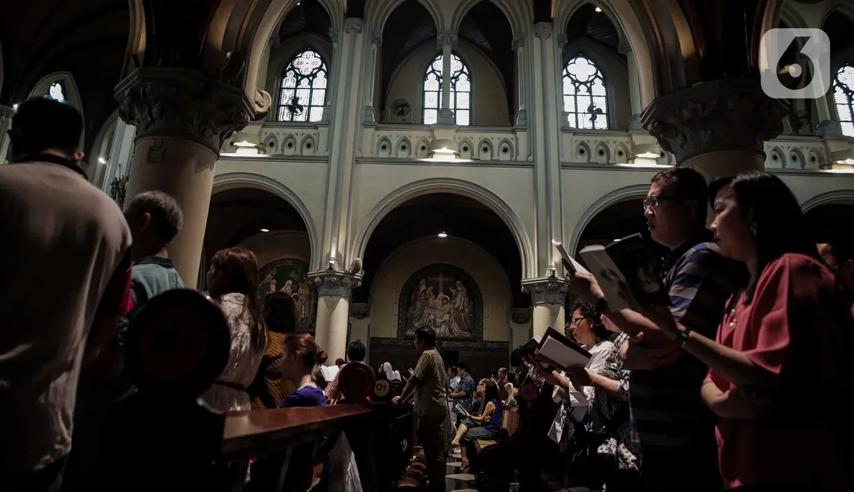 Jemaat melaksanakan misa malam Natal di Gereja Katedral, Jakarta, Selasa (24/12/2019). Jemaat memenuhi area dalam dan luar gereja. (Liputan6.com/Faizal Fanani)