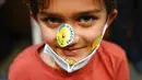 Paul Srinivasan (7) tersenyum saat menunjukkan stiker pada wajahnya usai menerima vaksinasi COVID-19 di Englewood Health, Englewood, New Jersey, Amerika Serikat, 8 November 2021. AS gelar vaksinasi COVID-19 untuk anak-anak berusia 5-11 tahun. (AP Photo/Seth Wenig)