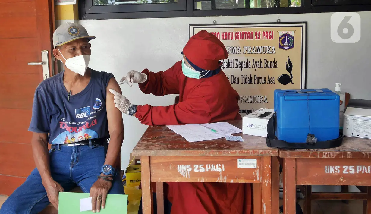 Petugas kesehatan dari Puskesmas Kecamatan Matraman melakukan vaksinasi COVID-19 di SD Negeri 25 Utan Kayu Selatan, Matraman, Jakarta Timur, Rabu (23/3/2022). Layanan vaksinasi digelar setiap hari Senin sampai Jumat pukul 08.00-11.00 WIB. (Liputan6.com/Herman Zakharia)