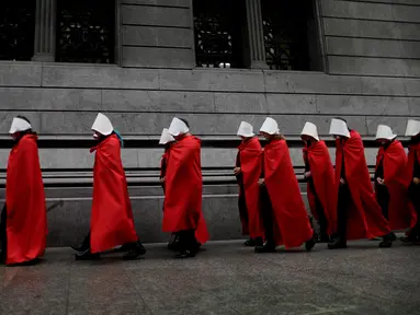 Aktivis yang mendukung dekriminalisasi aborsi berjalan di luar Kongres, Buenos Aires, Argentina, Rabu (25/7). Para aktivis mengenakan jubah merah dan topi putih seperti tokoh dalam serial televisi 'The Handmaid's Tale'. (AP Photo/Natacha Pisarenko)