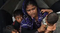Pengungsi Rohingya bersama anaknya menunggu bantuan di DWIP Sha Porir di Teknef (20/9). Tentara Bangladesh diperintahkan untuk membantu ratusan ribu orang Rohingya yang telah melarikan diri dari kekerasan di Myanmar. (AFP Photo/Dominique)