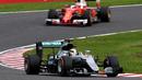 Pebalap Mercedes, Lewis Hamilton, mengungguli pebalap Ferrari, Sebastian Vettel, dalam balapan F1 GP Jepang di Sirkuit Suzuka, Jepang, Minggu (9/10/2016). (AFP/Toshifumi Kitamura)