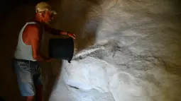 Alfred Attard menuangkan seember garam laut yang dikumpulkan dari dataran garam dengan pematang batu di sebuah desa di Gozo, Malta, 7 September 2020. Dikelilingi oleh laut, Malta merupakan salah satu produsen besar garam laut yang dihasilkan dari dataran garam berpematang batu (Xinhua/Jonathan Borg)