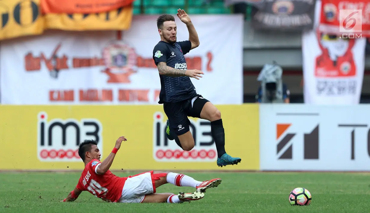 Bek PSM Makassar, Steven R A Paulle melompat menghindari tekel pemain Persija, Sandi Sute pada lanjutan Liga 1 Indonesia di Stadion Patriot Candrabhaga, Bekasi, Selasa (15/8). Laga berakhir imbang 2-2. (Liputan6.com/Helmi Fithriansyah)
