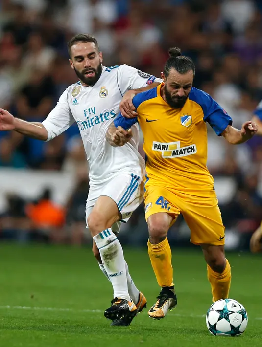 Bek Real Madrid, Daniel Carvajal berusaha merebut bola dari pemain APOEL Nicosia, Efstathios Aloneftis saat bertanding pada Grup H Liga Champions di stadion Santiago Bernabeu, Spanyol, (13/9). Madrid menang telak 3-0 atas APOEL. (AP Photo/Francisco Seco)