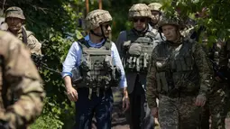 Presiden Ukraina Volodymyr Zelensky saat mengunjungi garis depan medan pertempuran dengan separatis pro-Rusia di Lugansk, Senin (27/5/2019). Zelenskiy mengenakan pakaian sipil, namun juga memakai helm militer dan rompi anti-peluru. (STR/UKRAINE PRESIDENTIAL PRESS SERVICE/AFP)