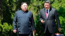 Pemimpin Korea Utara Kim Jong-un dan Presiden China Xi Jinping berbincang sambil berjalan di sela pertemuan di Dalian, Selasa (8/5). Ini adalah kunjungan kedua Kim ke China dalam dua bulan terakhir. (Korean Central News Agency/Korea News Service via AP)