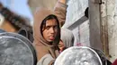 Sementara itu, mayoritas warga Gaza masih sepenuhnya bergantung pada dapur umum komunitas dan bantuan dari World Food Programme (WFP) yang menyediakan jatah tepung dan boks makanan untuk lebih dari satu juta orang. Tampak dalam foto, seorang anak pengungsi Palestina berebut untuk makanan di Khan Younis, selatan Jalur Gaza pada Jumat 6 Maret 2026. (Bashar Taleb/AFP)