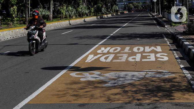 Kendaraan Roda dua melintasi Jalur Khusus Sepeda Motor dijalan Medan Merdeka Barat, Jakarta, Jumat (21/8/2020). Dalam pergub tersebut  Pemprov DKI Jakarta mengatur kendaraan yang diperkenankan melintas di wilayah ganjil genap. (Liputan6.com/Johan Tallo)