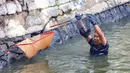 Sebelum dimusnahkan, ikan sapu-sapu yang tertangkap akan ditimbang dan didata. Tampak dalam foto, personel TNI AL saat operasi penangkapan ikan sapu-sapu di perairan kawasan Setu Babakan, Jakarta Selatan, Selasa (5/5/2026). (merdeka.com/Arie Basuki)