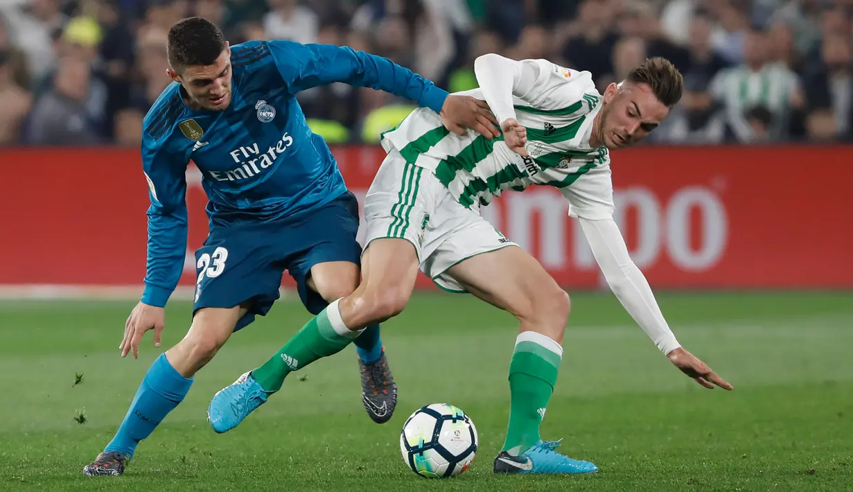 Pemain Real Madrid, Kovacic berebut bola dengan pemain Real Betis, Fabian pada laga pekan ke-24 La Liga Spanyol, di Estadio Benito Villamarin, Minggu (18/2). Melalui pertarungan sengit 8 gol, Real Madrid menang 5-3. (AP/Miguel Morenatti)