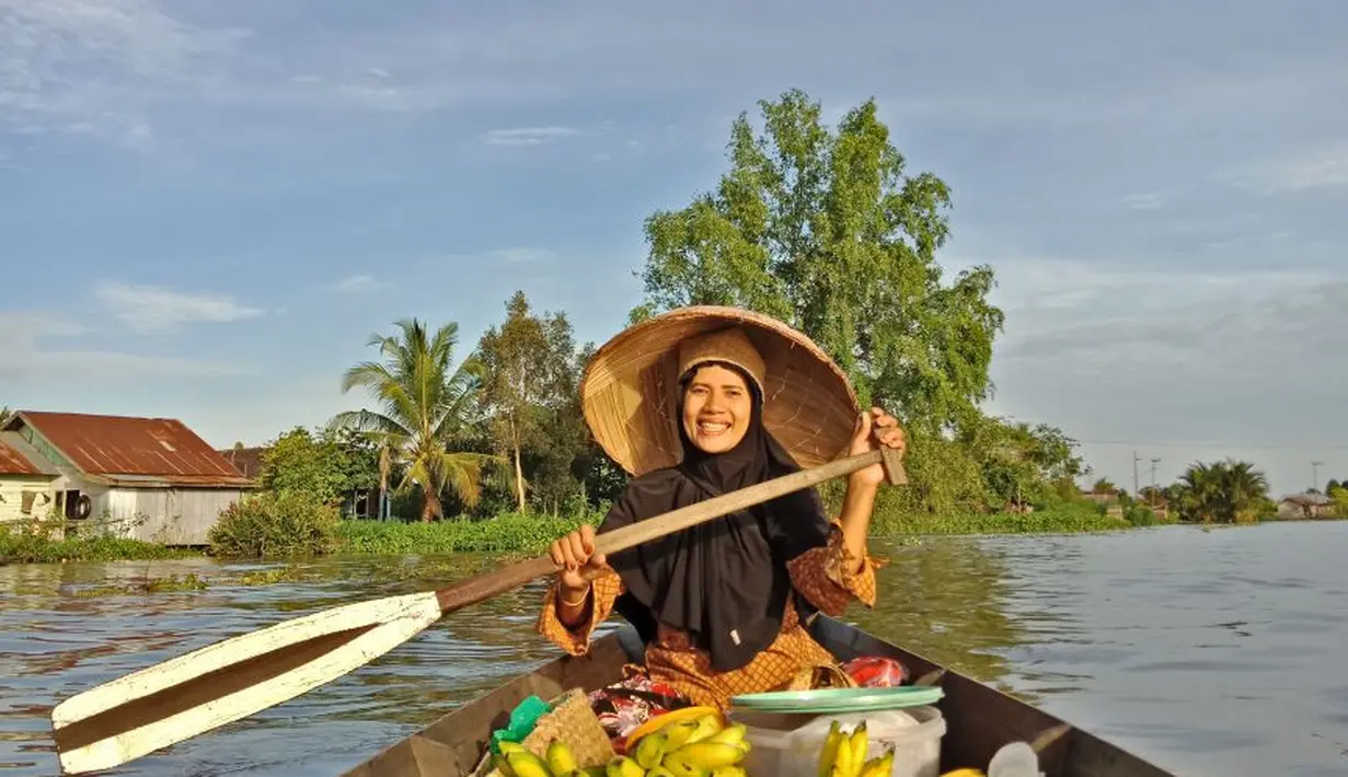 Pengunjung juga bisa naik ke jukung pedagang di Pasar Terapung Lok Baintan dan berfoto dengan persepektif berbeda (Liputan6.com/Pool/Kadek Arini)