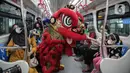 Seorang anak memegang Barongsai yang melakukan atraksi di dalam kereta LTR, Jakarta, Selasa (1/2/2022). Atraksi Barongsai tersebut bertujuan untuk menghibur penumpang LRT dalam rangka menyambut Tahun Baru Imlek. (Liputan6.com/Faizal Fanani)