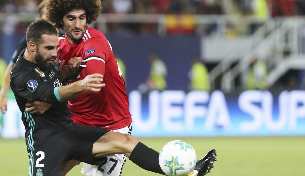 Gelandang Manchester United, Marouane Fellaini, berebut bola dengan bek Real Madrid, Daniel Carvajal, pada laga Piala Super Eropa di Stadion Philip II, Skopje, Selasa (8/8/2017). Foto muka unik Fellaini viral di media sosial. (AP/Boris Grdanoski)