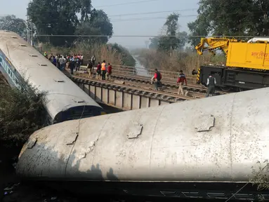 Sebuah kereta yang tergelincir di Kanpur, India utara, Rabu (28/12). Peristiwa tersebut mengakibatkan 2 orang tewas dan 43 lainnya luka-luka. (AFP PHOTO / SANJAY Kanojia)