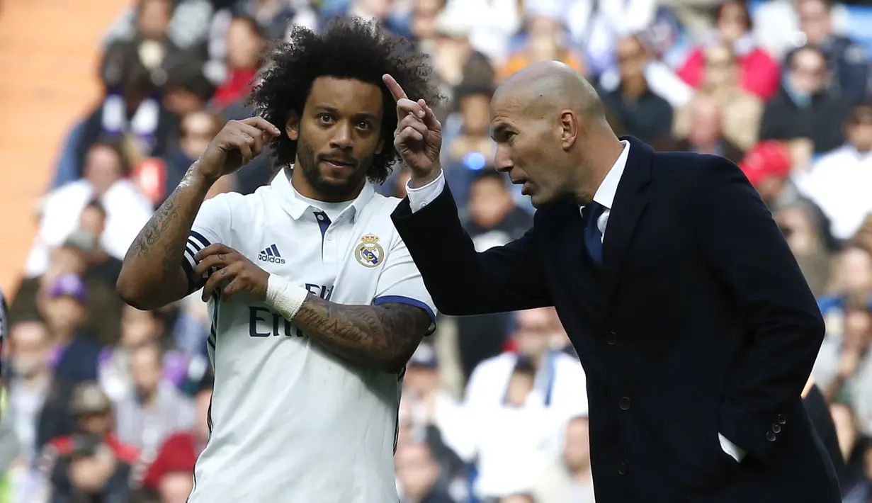 Pelatih Real Madrid, Zinedine Zidane (kanan) memberikan instruksi kepada kapten tim, Macelo pada lanjutan La Liga Spanyol 2016-2017 di Santiago Bernabeu stadium, Madrid, (6/11/2016). (EPA/Kiko Huesca)