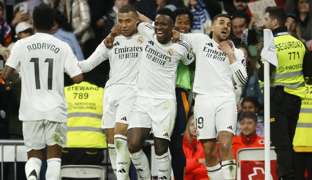 Pemain Real Madrid merayakan gol yang dicetak oleh Vinicius Junior dalam laga lanjutan Liga Spanyol 2024/2025 melawan Girona di Santiago Bernabeu Stadium, Madrid, Minggu (23/02/2025) waktu setempat. (AFP/Pierre-Philippe Marcou)