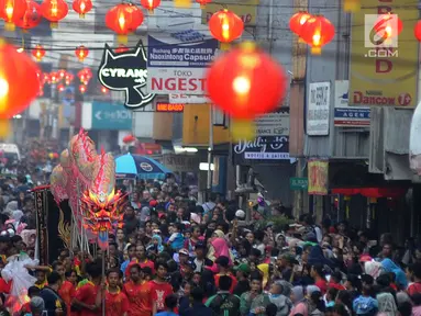 Warga memadati jalan raya saat arak-arakan atraksi liong perayaan Cap Go Meh melewati Jalan Suryakencana, Bogor, Jawa Barat, Selasa (19/2). Acara ini merupakan puncak perayaan Tahun Baru Imlek 2570. (Merdeka.com/Arie Basuki)