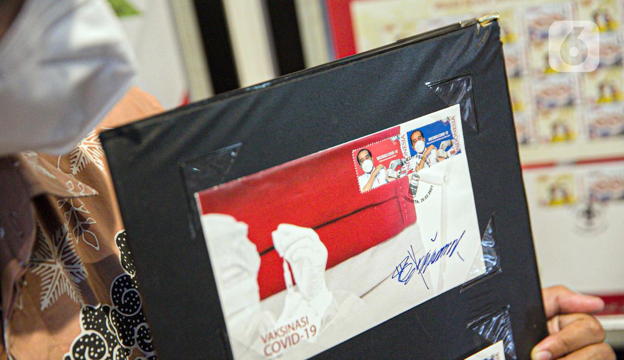 Petugas menunjukkan perangko seri vaksinasi COVID-19 di Kantor Filateli, Jakarta, Jumat (26/2/2021). Kementerian Komunikasi dan Informatika meluncurkan perangko seri vaksinasi COVID-19 bergambar Jokowi berkemeja putih dan memakai masker sedang disuntik vaksin. (Liputan6.com/Faizal Fanani)
